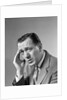 1960s Portrait Man In Suit and Tie With Wrinkled Brow Wincing and Holding Forehead by Anonymous