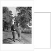 1930s 1940s Young Teen Couple Boy Girl Strolling Down Autumn Country Lane Arm In Arm by Anonymous