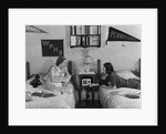 1930s 1940s Two Teen Girls Lying On Dormitory Beds Room Mates Listening To Radio College School Pennants On Wall by Anonymous