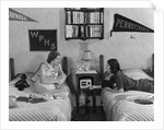 1930s 1940s Two Teen Girls Lying On Dormitory Beds Room Mates Listening To Radio College School Pennants On Wall by Anonymous
