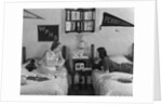 1930s 1940s Two Teen Girls Lying On Dormitory Beds Room Mates Listening To Radio College School Pennants On Wall by Anonymous