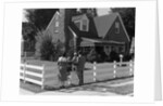1950s Family Standing By White Fence Looking At Brick House by Anonymous