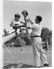 1950s Father Lifting Son And Daughter Onto A Playground Seesaw Outdoor by Anonymous