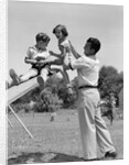 1950s Father Lifting Son And Daughter Onto A Playground Seesaw Outdoor by Anonymous