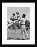1950s Father Lifting Son And Daughter Onto A Playground Seesaw Outdoor by Anonymous