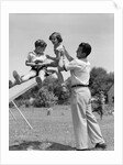 1950s Father Lifting Son And Daughter Onto A Playground Seesaw Outdoor by Anonymous