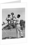 1950s Father Lifting Son And Daughter Onto A Playground Seesaw Outdoor by Anonymous