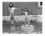 1930s 1940s Boys Playing Carnival Strongman One Lifting Dumbbells Other Announcing Act Through Megaphone by Anonymous
