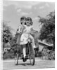 1940s Twin Girls Riding Outside On Tricycle by Anonymous