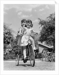 1940s Twin Girls Riding Outside On Tricycle by Anonymous