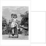 1940s Twin Girls Riding Outside On Tricycle by Anonymous