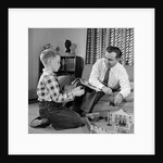 1950s Father And Son Playing With Cowboy Toy Game In Living Room Indoor by Anonymous