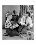 1950s Father And Son Playing With Cowboy Toy Game In Living Room Indoor by Anonymous