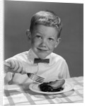 1960s Boy Wearing Bow Tie Eating Pie Dessert With Fork by Anonymous