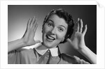 1950s Happy Woman Holding Hands Up Beside Her Head by Anonymous
