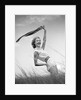 1950s 1960s Young Woman Bending Back Holding Scarf In The Wind Standing On Grassy Beach Dune by Anonymous