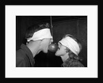1950s Blindfolded Couple Trying To Eat An Apple Hanging In Air From A String Inside by Anonymous