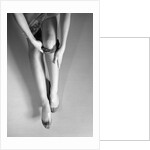 Woman's Hands Putting A Pair Of Sheer Stockings On Her Legs by Anonymous
