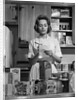 1960s Woman Housewife In Kitchen Checking Grocery Food Shopping List by Anonymous
