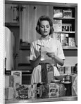 1960s Woman Housewife In Kitchen Checking Grocery Food Shopping List by Anonymous