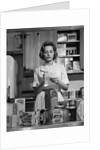 1960s Woman Housewife In Kitchen Checking Grocery Food Shopping List by Anonymous