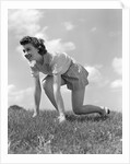 1940s Young Teen Woman Kneeling In Grass In Track Race Ready Starting Position by Anonymous