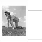 1940s Young Teen Woman Kneeling In Grass In Track Race Ready Starting Position by Anonymous
