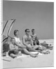1960s Family Portrait Mother Father Daughter And Two Sons Sitting On Beach Under Umbrella by Anonymous