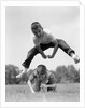 1960s Retro Boys Playing Leap Frog Outside Sky Grass Jump Jumping Crouching by Anonymous