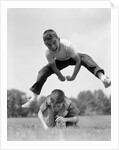 1960s Retro Boys Playing Leap Frog Outside Sky Grass Jump Jumping Crouching by Anonymous
