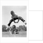 1960s Retro Boys Playing Leap Frog Outside Sky Grass Jump Jumping Crouching by Anonymous