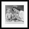 1960s Mother And Unhappy Baby Playing With Blocks by Anonymous