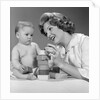 1960s Mother And Unhappy Baby Playing With Blocks by Anonymous