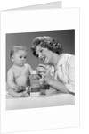 1960s Mother And Unhappy Baby Playing With Blocks by Anonymous