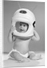 1960s Baby In Diaper Seated Holding Astronaut Helmet With Antennae On Head by Anonymous