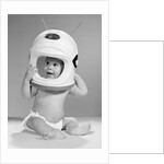 1960s Baby In Diaper Seated Holding Astronaut Helmet With Antennae On Head by Anonymous
