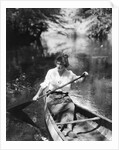 1920s Woman With Upswept Hair Paddling Wooden Canoe In Stream by Anonymous