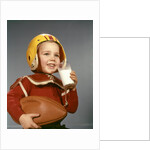 1950s 1960s Boy Drinking Glass Milk Wearing Football Helmet Shoulder Pads by Anonymous