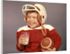 1950s 1960s Boy Drinking Milk Wearing Football Helmet Red Jersey Holding Ball by Anonymous