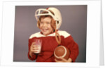 1950s 1960s Boy Drinking Milk Wearing Football Helmet Red Jersey Holding Ball by Anonymous