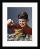 1950s 1960s Boy Pouring Syrup On Breakfast Pancakes by Anonymous