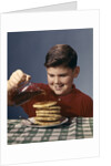 1950s 1960s Boy Pouring Syrup On Breakfast Pancakes by Anonymous