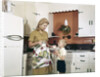 1970s Mother Handing Glass Of Milk To Son In Kitchen by Anonymous