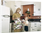 1970s Mother Handing Glass Of Milk To Son In Kitchen by Anonymous