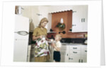 1970s Mother Handing Glass Of Milk To Son In Kitchen by Anonymous