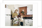 1970s Mother Handing Glass Of Milk To Son In Kitchen by Anonymous