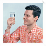 1960s Profile Man Wearing Red Checkered Shirt Holding Glass Of Water by Anonymous