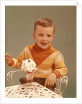 Boy Sitting At Ice Cream Parlor Table Eating Whipped Cream Cherry Topped Sundae+ by Anonymous
