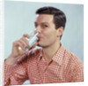1960s Man Drinking Glass Water Wearing Red Checkered Shirt by Anonymous