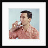 1960s Man Drinking Glass Water Wearing Red Checkered Shirt by Anonymous